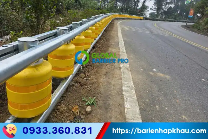 Hộ lan xoay chống lật xe màu vàng có decal phản quang, giúp bảo vệ an toàn trên đường đèo, dốc.